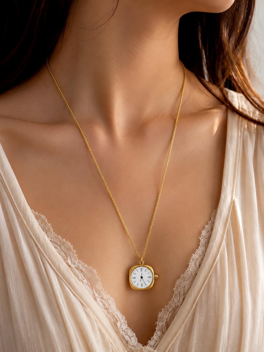 Small Stainless Steel gold watch pendant necklace with a polished plain back on a long gold chain, displayed as a minimalist everyday necklace for women.