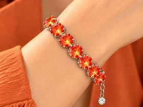 Woman wearing a bold orange crystal tennis  bracelet with large round Swarovski Rivoli stones on her wrist.